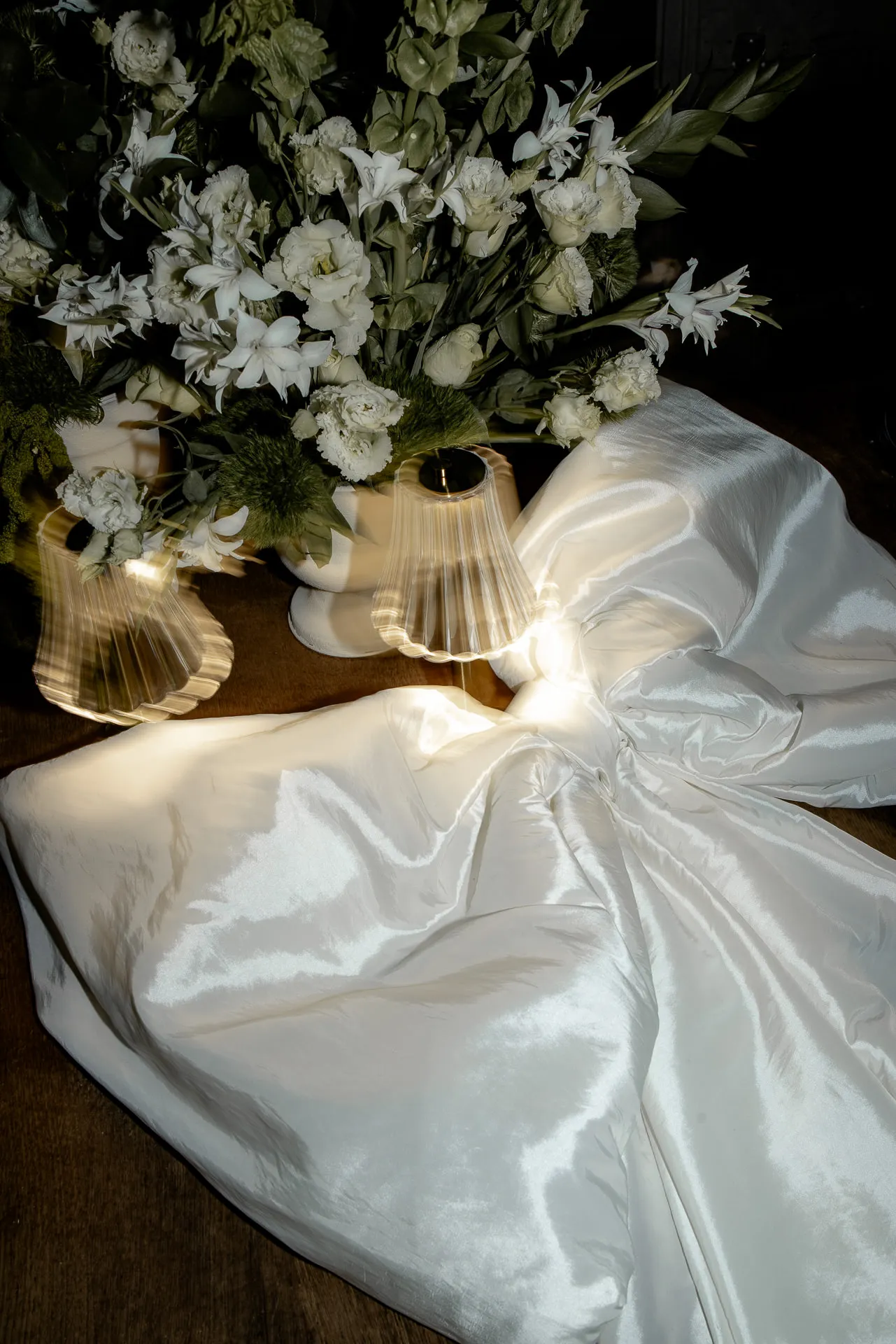Elegante Brautkleid-Details mit weißen Blumen und Lampe bei Hochzeit am Chateau de Varennes